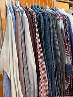 Full row of assorted patterned shirts on hangers