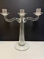 Front view of clear glass three-arm candelabra