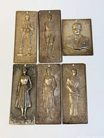 Six metal votive plaques arranged for size and design overview