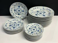 Stacked set showing nine large shallow bowls, five lunch plates, eight side plates; blue floral pattern visible