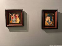 Both framed ceramic tile artworks hanging side by side on wall