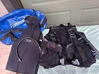 Full lot view: BCD, hooded wetsuit jacket, blue Fission bag, inflator hose