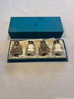 Set of four crystal shakers with sterling silver and mother-of-pearl tops inside original turquoise Birks box