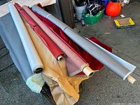 Multiple fabric rolls on table showing variety of colours and materials