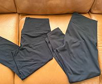 Two black Lululemon leggings laid out on couch