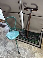 Green metal folding seat and brown cane seat side by side