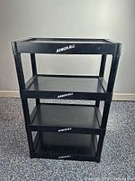 Front view of black Armor All four-shelf plastic unit