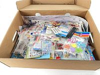 open cardboard box showing assorted packaged stickers and foam shapes