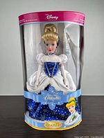 Cylindrical box front displaying doll and accessories