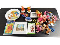 Group shot of entire lot showing plate, figurines, plush keychains, boxed tiles and patch
