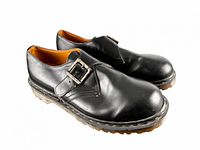 Side view showing black leather uppers, buckle, and platform sole