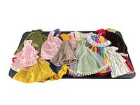 Full group of 23 doll dresses arranged on surface