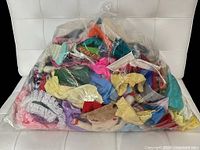 Full plastic bag containing mixed doll garments