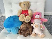 Group shot of all five plush animals on chair