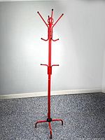 Full view of red metal coat and hat rack standing upright