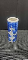 Front view of cylindrical blue and white porcelain vase with plum blossom motif