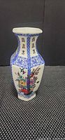 Front view of porcelain vase showing floral and bird motifs with blue borders
