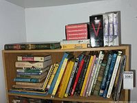Top of bookshelf showing stacked books and six VHS tapes