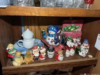Full shelf view showing teapots, egg coddler, plate, shakers and figurines