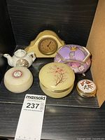 Group view of clock, four trinket boxes and mini teapot