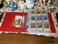 Binder open showing comic/super-hero power profile cards and loose items