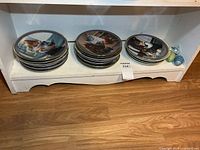 Three stacks of collector plates on shelf