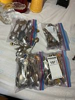 Four Ziploc bags filled with collector spoons on table
