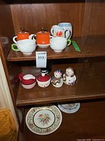 Overview of lot on shelving showing sugar bowls, creamers, shakers and plates
