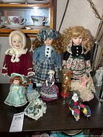 Group of all nine dolls and figurines displayed on table