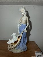 Full view of porcelain figurine showing woman in bonnet, wheelbarrow and puppy