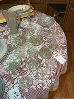 Group of assorted glass flower frogs with pitcher, flute and bowl on table