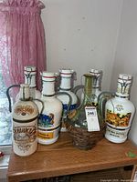 Group of six porcelain swing-top bottles and one glass demijohn