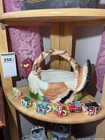 Overall view of chicken basket and six teapots on shelf