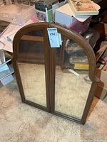 Front view of arched wooden framed mirror with two panes