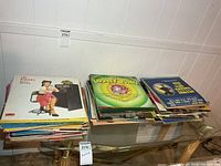 Two stacks of LP records on glass table; top albums Looney Tunes, Jim Reeves, Lily Pons