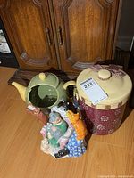 Green ceramic teapot, burgundy snowman canister with lid, multicolour cat planter grouped