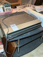 Front three-quarter view showing RCA SelectaVision VideoDisc Player with power cord on stand