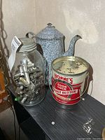Horne's peanut butter tin, glass jar of spiles, enamelware kettle on shelf