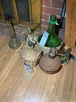 Group of six vintage liquor bottles showing sizes and wicker coverings
