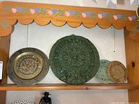 All four wall decor pieces displayed on shelf