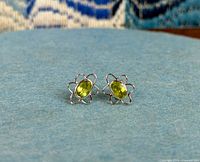 Front view of both stud earrings showing peridot gemstones and flower design