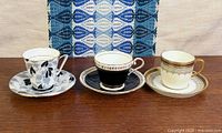All three demitasse cup and saucer sets side by side