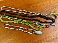 Overview of all four gemstone necklaces laid out on table