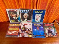 Six bagged magazines displayed upright