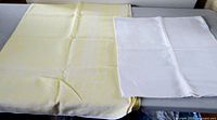 Folded yellow and white tablecloths side by side