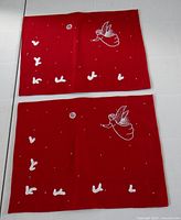 Both red embroidered placemats side by side
