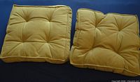 Two lime green tufted cushions side by side