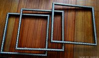 Three matching wood frames arranged overlapping on wood surface