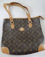 Front view of brown patterned tote with tan handles and trim