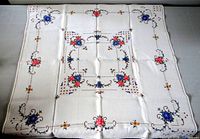 Full view of square white tablecloth showing overall embroidered floral pattern